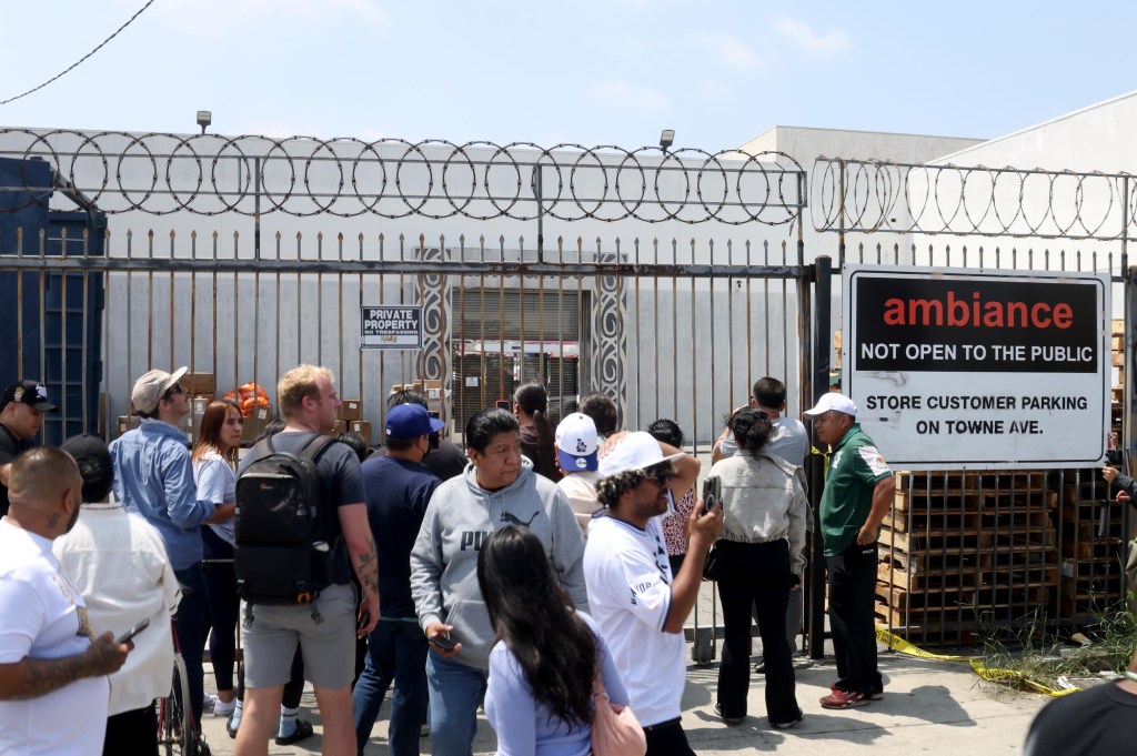 LOS ANGELES, CA - JUNE 6, 2025 - - People gather in front of Ambiance Apparel after several employees were taken into custody by federal agents in the Garment District in downtown Los Angeles on June 5, 2025. Protesters gathered at that location and at one point, federal agents had to shove protesters out of the path of a van that was being driven into the building's parking lot. (Genaro Molina/Los Angeles Times via Getty Images)