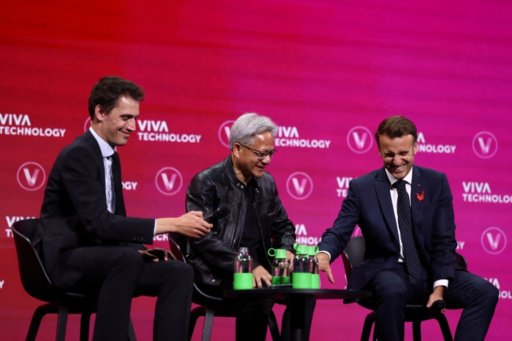 Founder and CEO of Mistral AI Arthur Mensch (L), Nvidia CEO Jensen Huang (C) and France's President Emmanuel Macron (R) attend a round table discussion at the VivaTech technology startups and innovation fair at the Paris Expo Porte de Versailles, in Paris on June 11, 2025. The VivaTech fair opened in Paris on June 11, 2025 in the presence of the French Minister for Digital Technologies, before welcoming a number of tech stars and the French President against a backdrop of trade tensions between Europe and the United States. (Photo by Sarah Meyssonnier / POOL / AFP) (Photo by SARAH MEYSSONNIER/POOL/AFP via Getty Images)