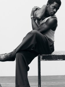 Hanro cotton tank top; Lanvin wool-woven pleated trousers; Amiri belt; Ferragamo shoes; IWC Ingenieur Automatic 35 gold-colored watch with gold case; all jewelry by Didris.