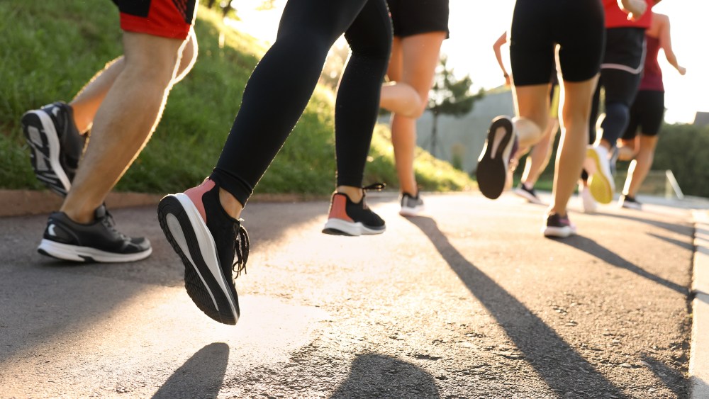 Group of people running outdoors on sunny day, like on Global Running Day, which takes place the first Wednesday of June every year.