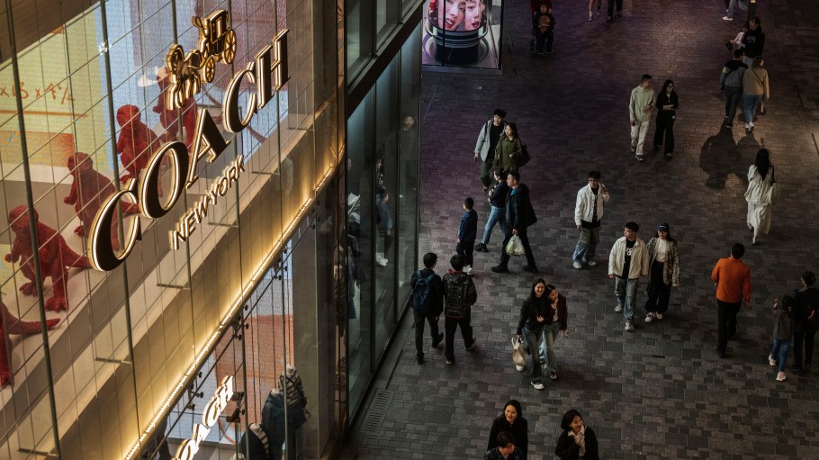 Shoppers walk by a Coach store in Beijing.