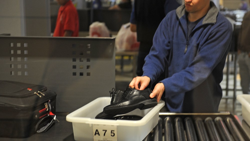An air traveler places his shoes in a bin before passing through the Transportation Security Administration (TSA) security check at  Los Angeles International Airport (LAX) on February 20, 2014 in Los Angeles, California. The TSA recently launched a PreCheck program that allows those enrolled in a trusted traveler network to enter about 100 US airports through a special security lane where they dont have to take off shoes, belts and jackets or remove laptops, liquids or gels.  AFP PHOTO / ROBYN BECK        (Photo credit should read ROBYN BECK/AFP via Getty Images)