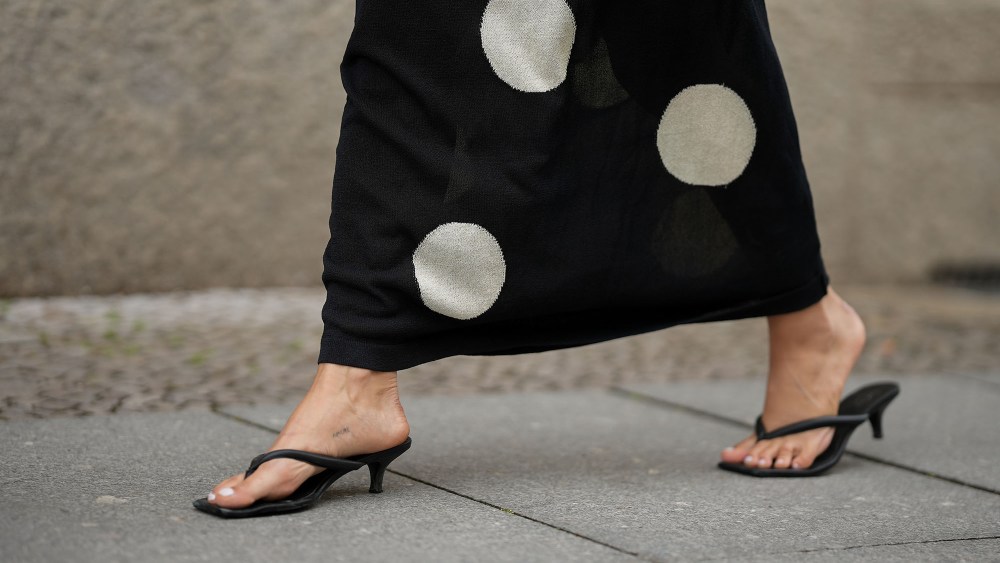 a woman wears a pair of heeled flip-flops