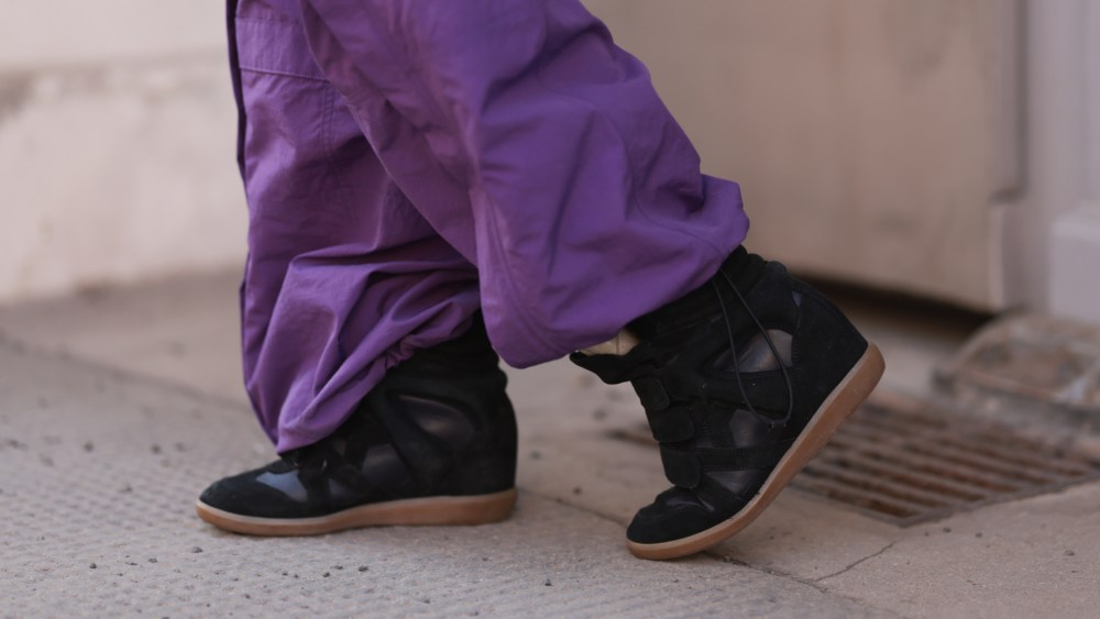 Isabel Marant's sneaker with hidden wedge seen in Vienna in 2025.