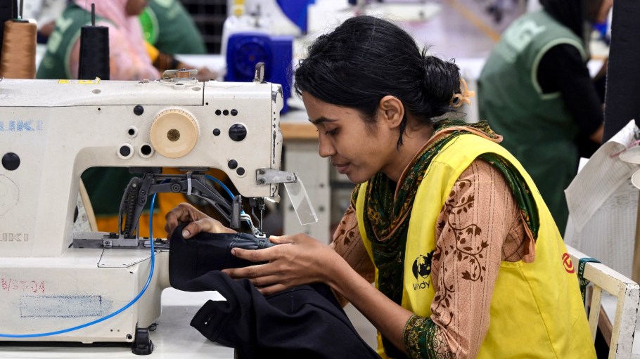 A garment worker tailors a cloth at her sewing station in a garment factory in Tongi, on the outskirts of Dhaka on July 6, 2025.
