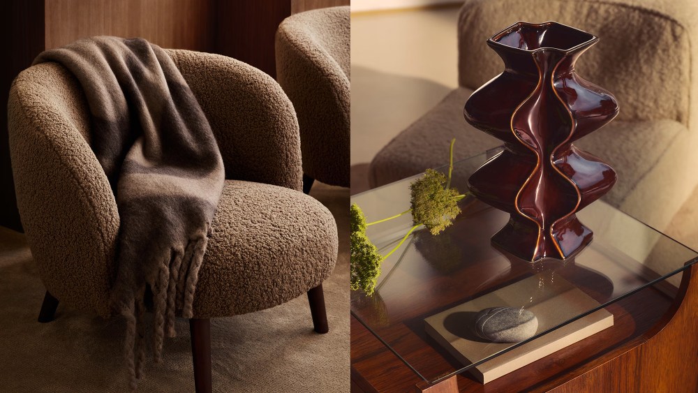 boucle chair with draped throw in a brown color on it; glass coffee table with flowers and a sculptural brown vase resting on top