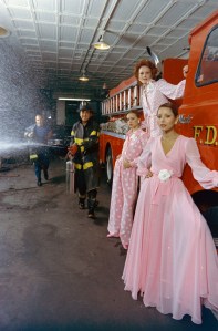 Designer Oscar de la Renta, models and members of New York Fire Department, Engine 18. Model Barbara Carrera.