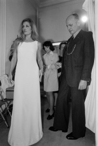 French designer Pierre Balmain adjusts a dress on Egyptian-Italian singer Dalida before her show at the Olympia concert hall, 1974.