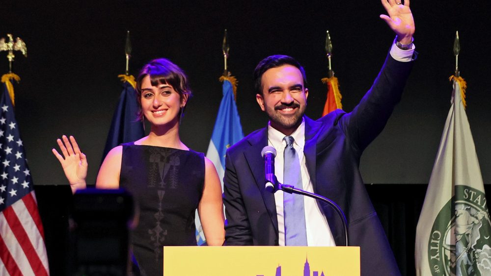 NEW YORK, NEW YORK - NOVEMBER 04: New York City Democratic mayoral candidate Zohran Mamdani waves with his wife Rama Duwaji (L) after delivering remarks at his election night watch party at the Brooklyn Paramount on November 4, 2025 in the Brooklyn borough of New York City. Mamdani defeated Independent candidate Andrew Cuomo and Republican candidate Curtis Sliwa in the closely watched election for New York City mayor.  (Photo by Michael M. Santiago/Getty Images)