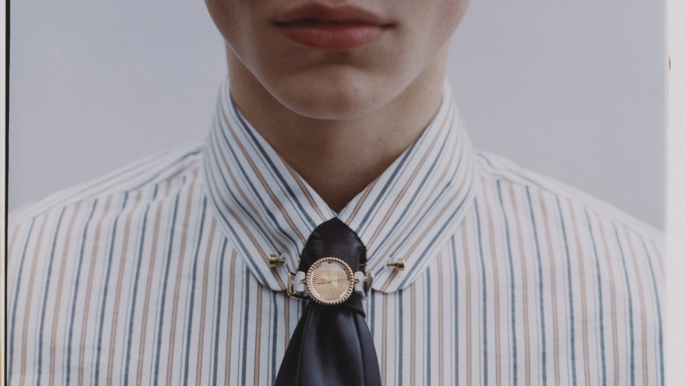 Van Cleef & Arpels Perlée watch in 18-karat yellow gold with an alligator strap (worn around tie); Loro Piana cotton and silk shirt and brass tie bar; Saint Laurent sunglasses; Sandro leather tie.