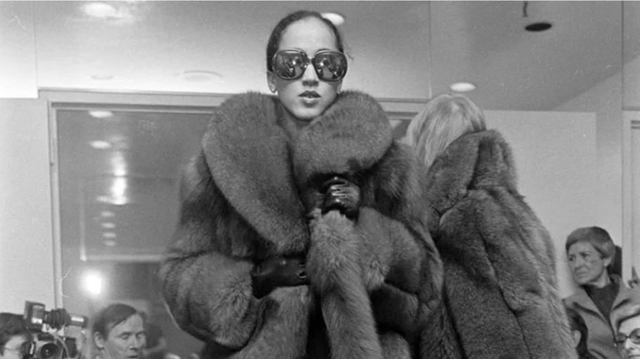 Model Pat Cleveland walks the runway in a fur coat and sunglasses from Halston's fall 1977 ready-to-wear collection.