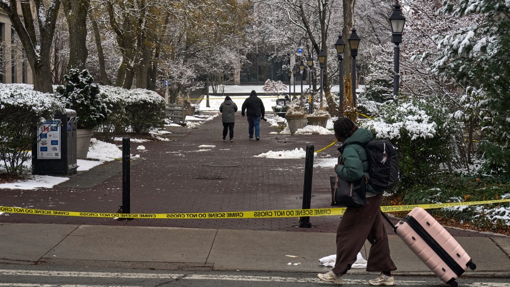 A Brown University student carries her luggage as she departs campus after final exams were cancelled the following day of a mass shooting at Brown University, in Providence, Rhode Island on December 14, 2025. US authorities on Sunday detained a person of interest in the mass shooting at Brown University that left two people dead and nine others wounded, the latest in a long line of school attacks nationwide.