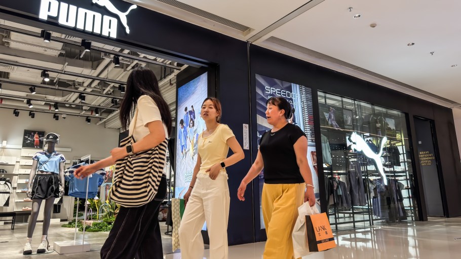 Shoppers walk past a PUMA retail store, with the brand’s logo and activewear displays visible through the storefront, on May 31, 2025 in Chongqing, China. German sportswear giant PUMA is ramping up its presence in Asia as part of its global strategy to boost sales, focusing on youth-oriented branding, lifestyle fashion, and performance products amid growing competition in the athletic apparel market.