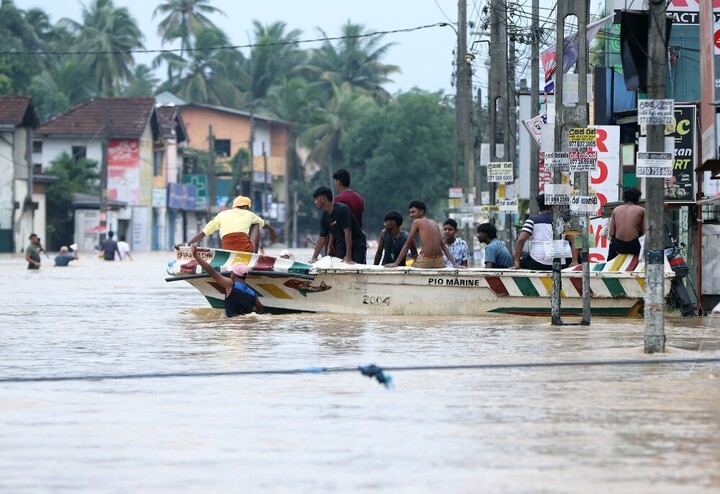 People evacuate by boat in floodwater after heavy rains on the outskirts of Colombo, Sri Lanka, on Nov. 29, 2025.