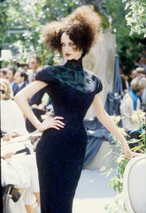Fitted black beaded gown with shoulder pads, high collar and peacock feather neckline in the Christian Dior Fall Couture 1997 show in Paris (Photo by Giovanni Giannoni/WWD/Penske Media via Getty Images)