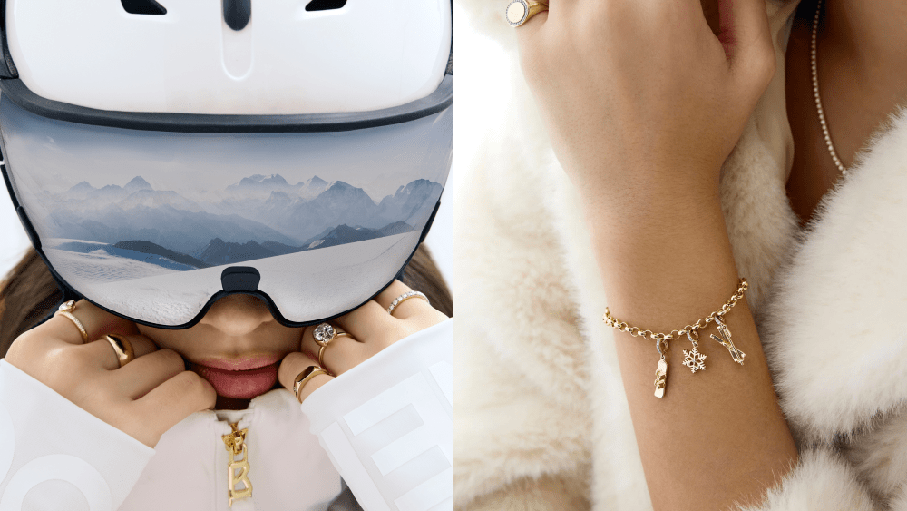 woman in ski mask that reflects an alpine view, wearing multiple rings on her fingers; model's arm displaying charm bracelet loaded up with ring concierge x bogner wintertime charms