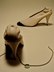 Beck Jewels Ripple choker with a cushion emerald on leather; Chanel lambskin pumps.