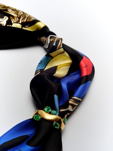 Verdura Wave cuff from The Virgin Gold™Collection with emerald gemstones in 22-karat gold; Celine silk twill scarf; L’Objet Ripple napkin rings in platinum.