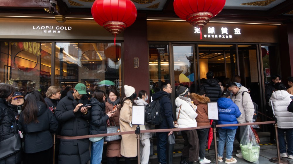 Shoppers queue in a long line in front of Laopu Gold Jewelry shop in Shanghai
