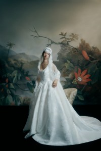 Justin Alexander Signature Mikado Serata gown with tonal beading; Monvieve French Chantilly lace veil; Jennifer Behr lace juliet cap; Ben-Amun pearl glass pearl and crystal 
headband; Sophie Bille Brahe 14-karat certified recycled 
yellow gold with freshwater pearls colonna grande earrings; Ettika sea-born pearl ring and Nickho Rey JR ring.