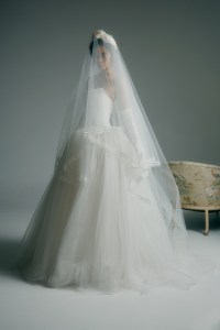 Katherine Tash silk crepe Cosima gown with a tulle 
ballskirt; Lele Sadoughi headband; Amsale duchess satin veil with pearl beaded ribbon trim; Carolina Amato gloves.