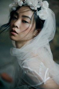 Honor taffeta cape and organza gown with glass embroidered neckline, cellophane hem and ribbon accents; Jennifer Behr tulle veil with silk organza flowers; stylist’s own gloves; Lele Sadoughi pearl bracelet.
