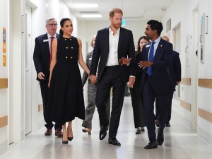 MELBOURNE, AUSTRALIA - APRIL 14: Meghan, Duchess of Sussex and Prince Harry, Duke of Sussex talk with Kog Ravindran, chief of staff to the CEO & executive director of communications at the Royal Children's Hospital, during a visit on April 14, 2026 in Melbourne, Australia. The royal couple are on a four-day visit to Australia, with engagements across Melbourne, Canberra and Sydney. (Photo by Jonathan Brady-Pool/Getty Images)