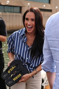 SYDNEY, AUSTRALIA - APRIL 17: Meghan, Duchess of Sussex is presented with custom thongs which reads "G'Day Megs" by Invictus Australia veteran Joel Vanderzwan at the Sydney Opera House on April 17, 2026 in Sydney, Australia. The Duke and Duchess of Sussex are on a four-day visit to Australia, with engagements across Melbourne, Canberra and Sydney. (Photo by Cameron Spencer/Getty Images)