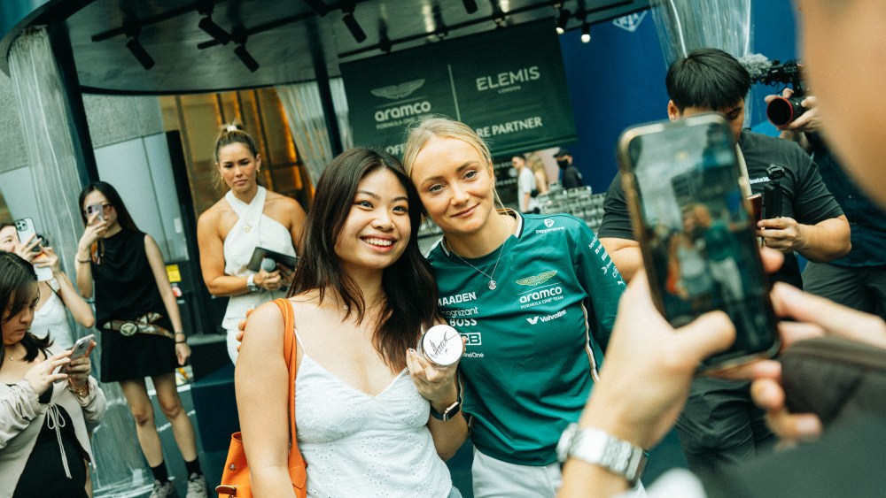 Elemis ambassador Jessica Hawkins posing with F1 fans at the Singapore Grand Prix.